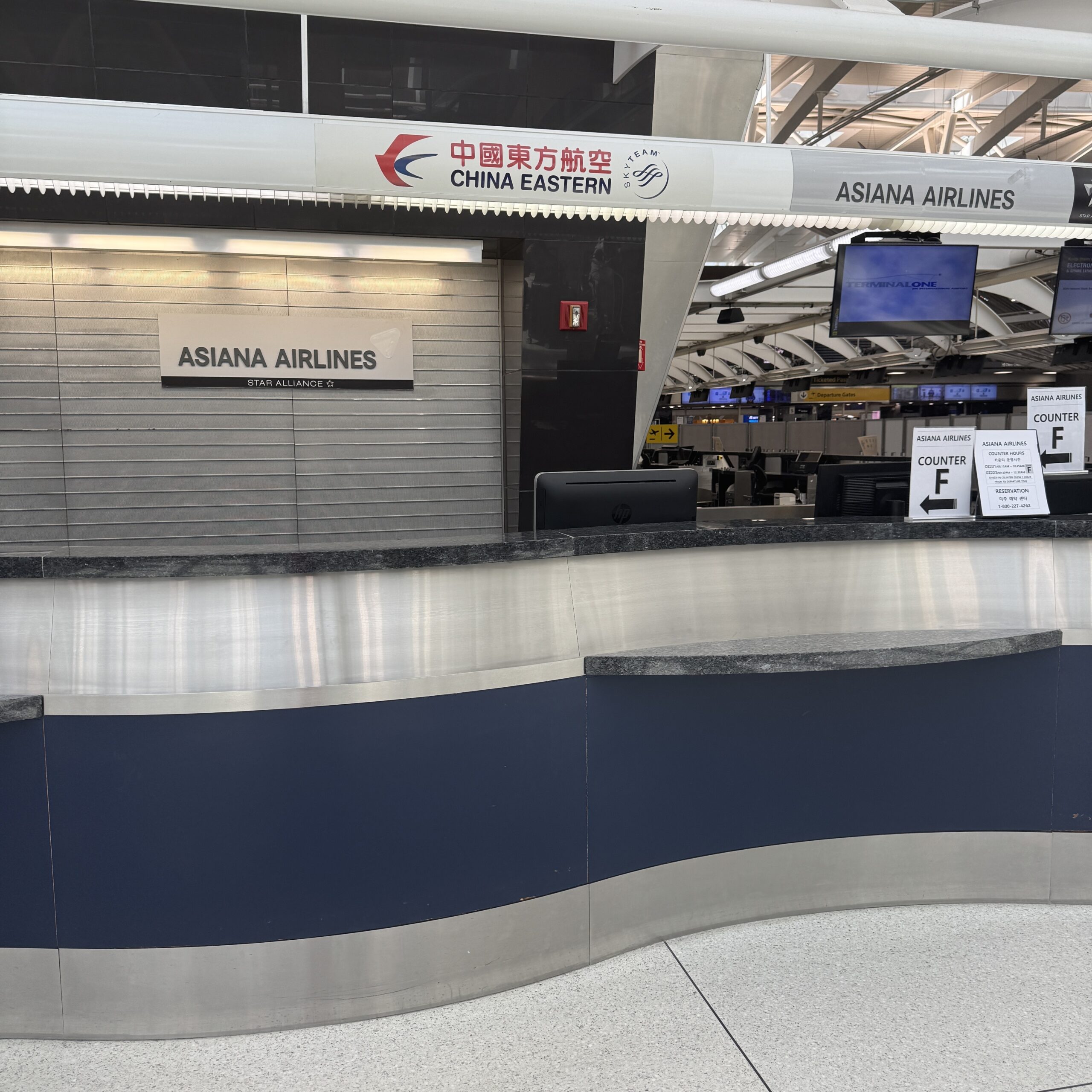 Asiana Airlines Counter at JFK Terminal 1 on April 9, 2026, showing posted counter hours. Counter staffed only 0815 AM - 1045 AM and 0830 PM - 1235 AM.